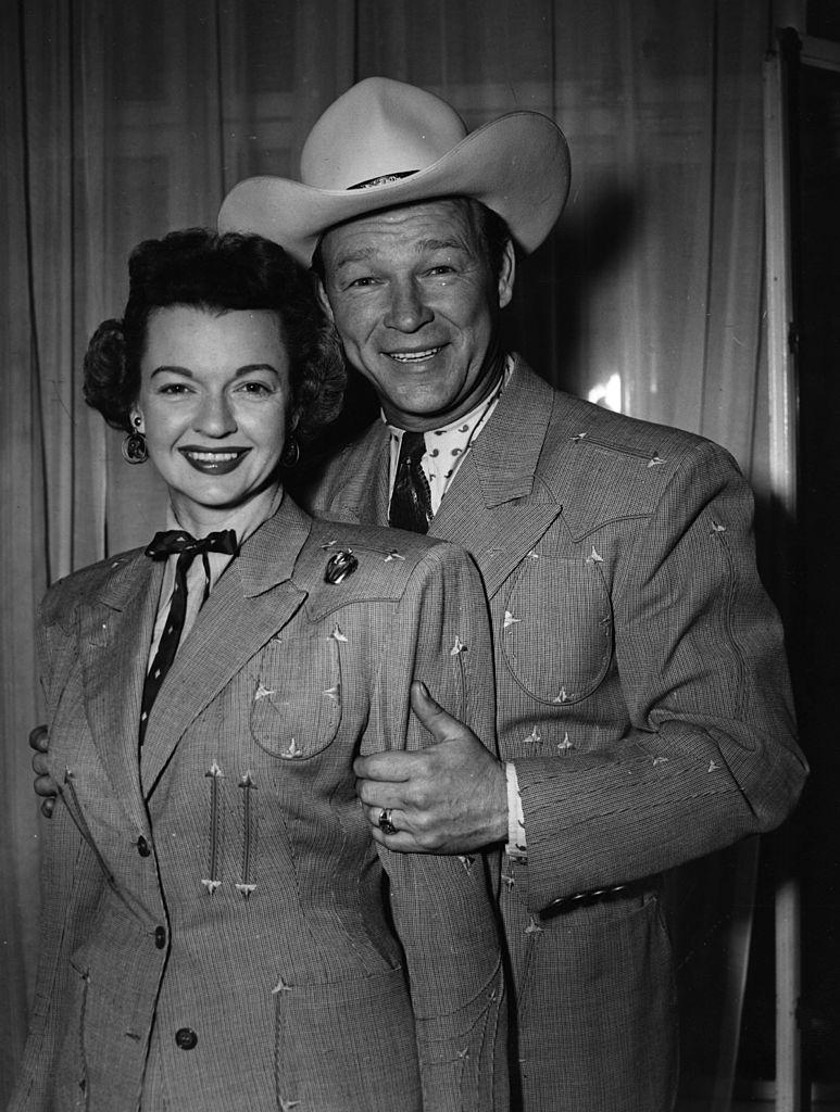 Rogers holding the arms of his wife in a photoshoot on Feb. 10, 1954 (©Getty Images | <a href="https://www.gettyimages.com.au/detail/news-photo/roy-rogers-the-screen-name-of-leonard-slye-the-american-news-photo/3281995">Monty Fresco/Topical Press Agency</a>)