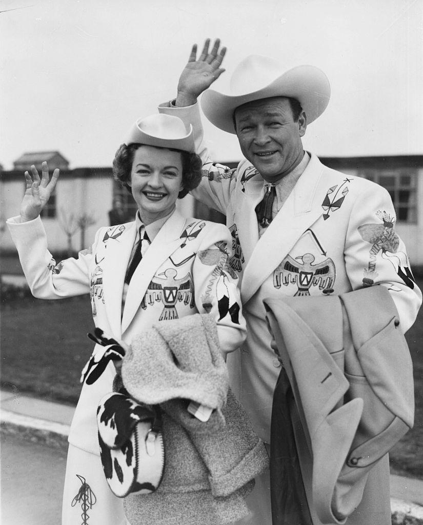 Dale Evans and Roy Rogers in "Wild West" costumes, waving as they arrive at London Airport on Feb. 10, 1954 (©Getty Images | <a href="https://www.gettyimages.com.au/detail/news-photo/actor-roy-rogers-the-king-of-cowboys-and-his-wife-dale-news-photo/585320577">Douglas Miller/Keystone</a>)
