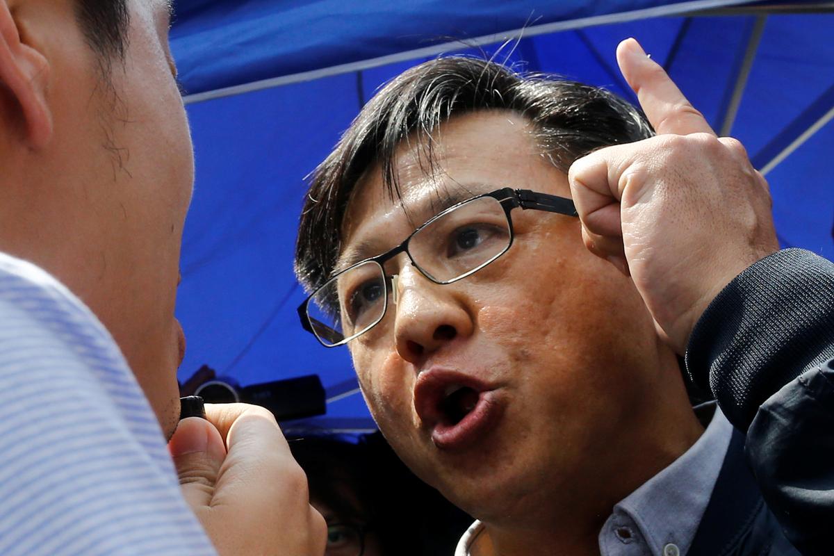 Pro-Beijing lawmaker Junius Ho argues with a pro-democracy lawmaker before demonstration of a water cannon equipped vehicle at the compound of the Police Tactical Unit in Hong Kong, China on Aug. 12, 2019. (Thomas Peter/Reuters)