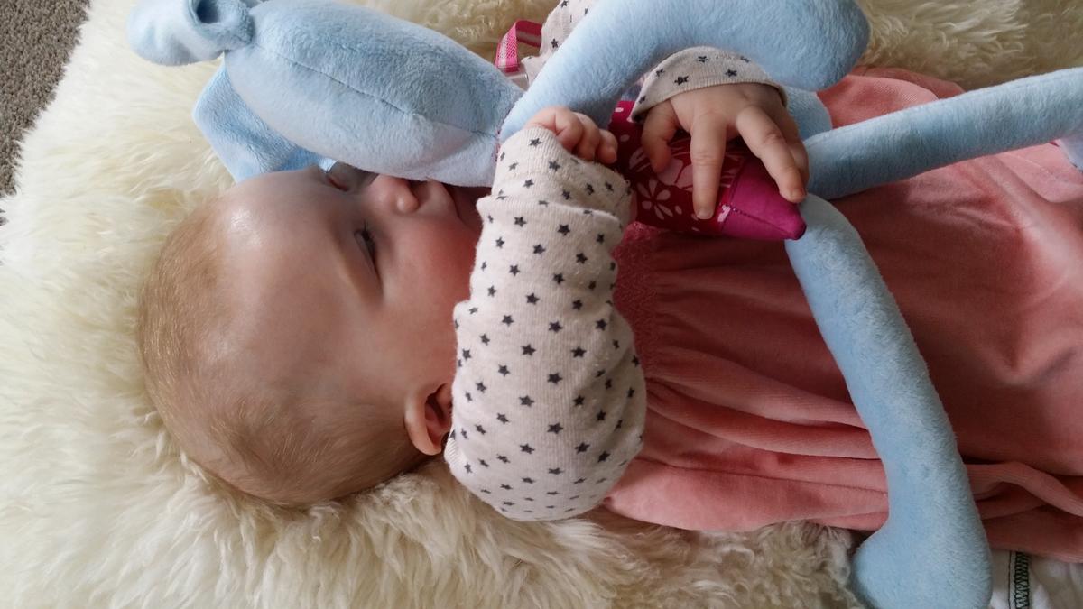 Eva kissing her blue bunny made by her aunty, and lying on a sheepskin at her home she shared with her mother and another family. (Photo courtesy of <a href="http://theoneinamillionbaby.com/">Tessa Prebble</a>)
