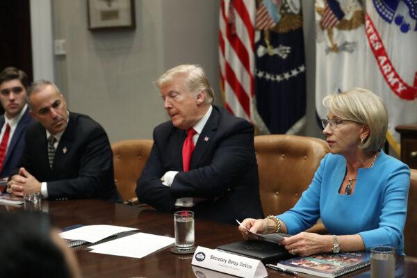 Andrew Pollack (L), whose daughter Meadow Pollack was killed in the mass shooting at Stoneman Douglas High School in Parkland, Florida, participates in a roundtable discussion with U.S. President Donald Trump (C) and Education Secretary Betsy DeVos (R) about school safety and the new Federal Commission on School Safety report with family members of shooting victims, alongside state and local officials, in the Roosevelt Room at the White House on December 18, 2018 in Washington, DC. (Photo by Mark Wilson/Getty Images)