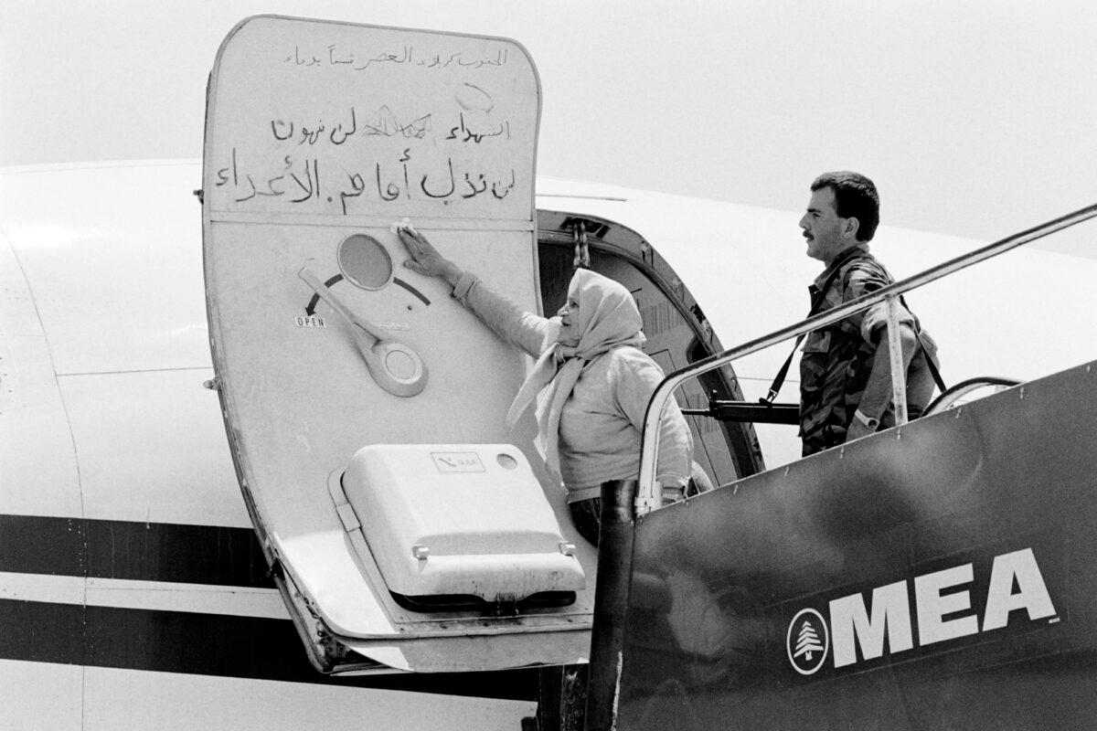 A Lebanese woman cleans the slogans which have been writting by the hijackers on the door of the TWA plane at Beirut airport, on July 6, 1985. (Mohammed Attar/AFP/Getty Images)