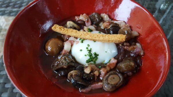 Snails in red wine with bacon and poached egg at Château d'Igé. (Wibke Carter)