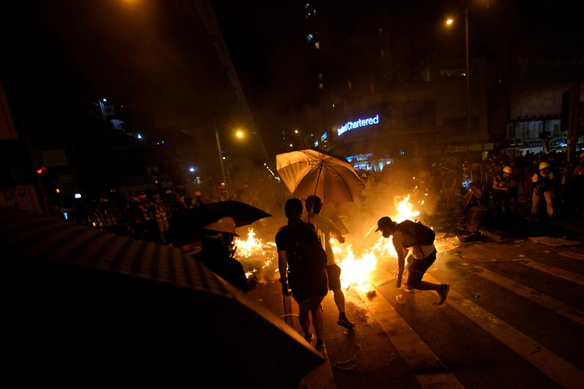 Anti-government protesters set a fire during a rally outside Mong Kok police station, in Hong Kong on Sept. 22, 2019. (Aly Song/Reuters)