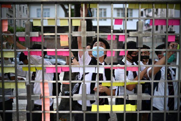Secondary school students display handwritten notes as part of a Lennon Wall outside their school gate in Hong Kong on Sept. 23, 2019. (Anthony Wallace/AFP/Getty Images)