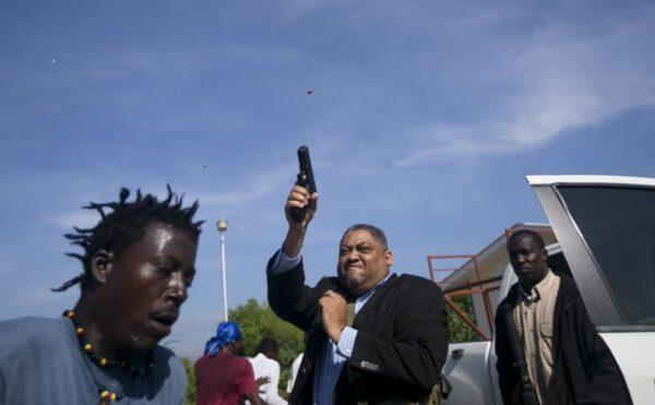 Ruling party Senator Ralph Fethiere fires his gun outside Parliament as he arrives for a vote on the ratification of Fritz William Michel's nomination as prime minister in Port-au-Prince, Haiti, on Sept. 23, 2019. (Dieu Nalio Chery/AP Photo)