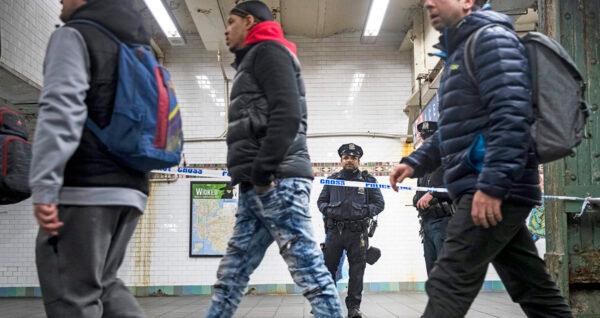 Commuters exit a train as a police officer stands in a cordoned off subway station walkway in New York in a file photo. (Drew Angerer/Getty Images)