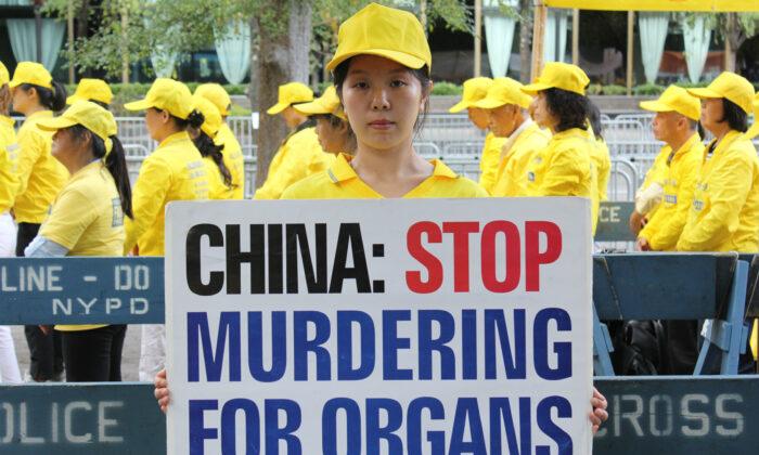 A Falun Gong practitioner holds a placard at rally at the United Nations Plaza on Sept. 24, 2019. (Eva Fu/The Epoch Times)