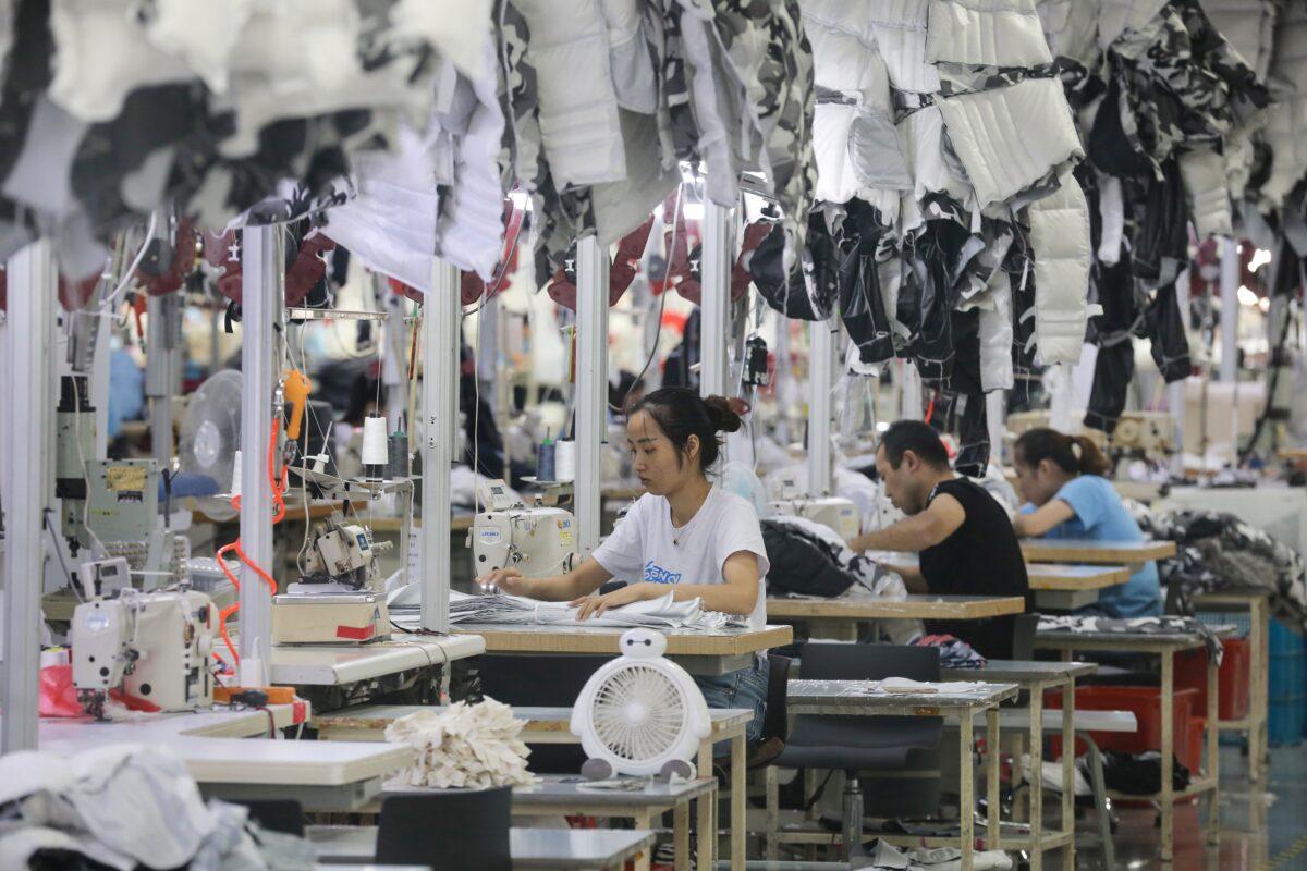 Workers are sewing down coats in a factory for Chinese clothing company Bosideng in Nantong, Jiangsu Province, China, on Sept. 24, 2019. (STR/AFP/Getty Images)