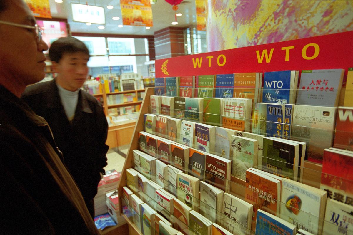 Chinese men look at books from a World Trade Organization (WTO) bookstand in a bookshop in Beijing, China on Nov. 5, 2001. China became a member of the WTO on Dec. 11, 2001. (Peter Rogers/Getty Image)