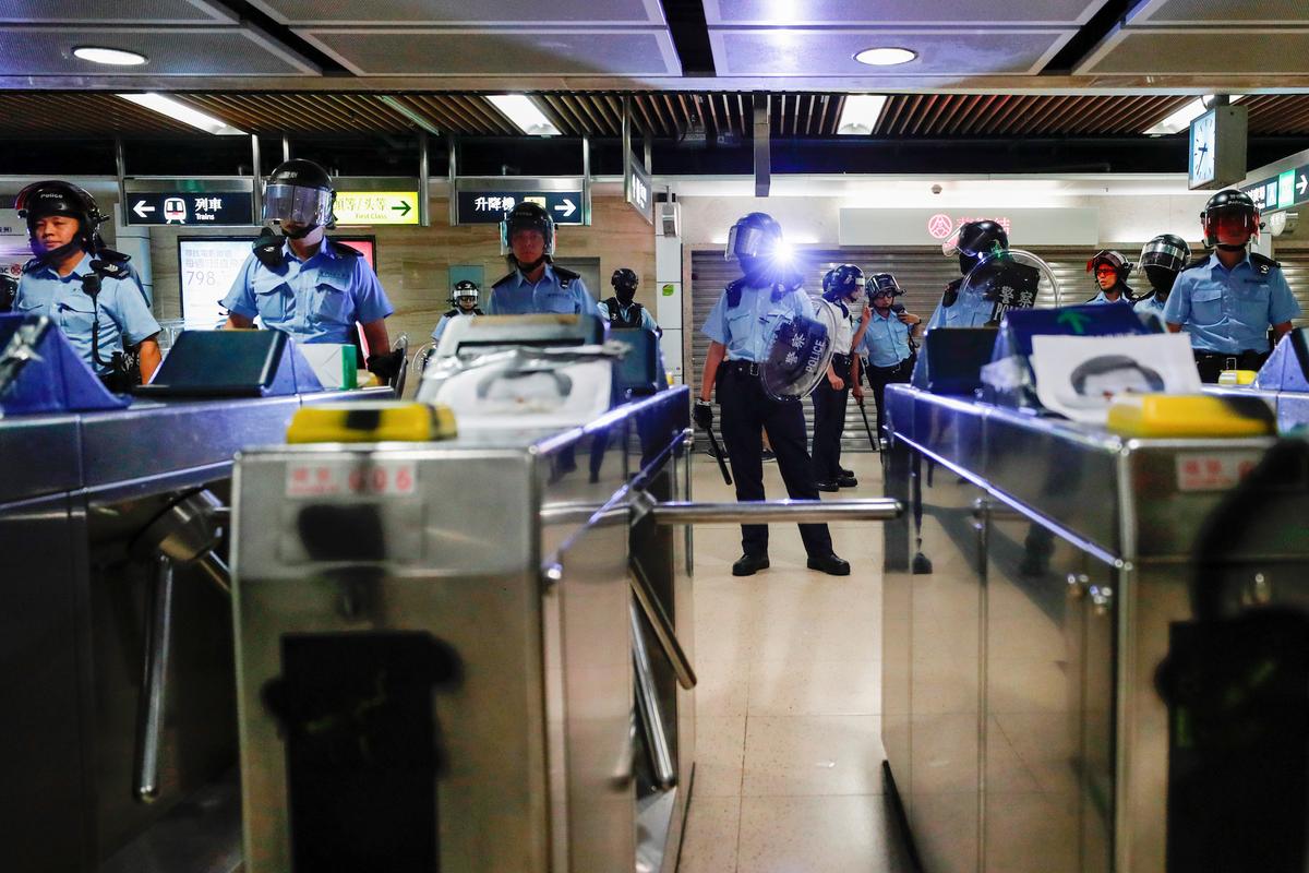 Riot police stand guard inside Sha Tin Mass Transit Railway (MTR) station as anti-government protesters gather to demonstrate against the railway operator, which they accuse of helping the government, in Hong Kong, China on Sept. 25, 2019. (Tyrone Siu/Reuters)
