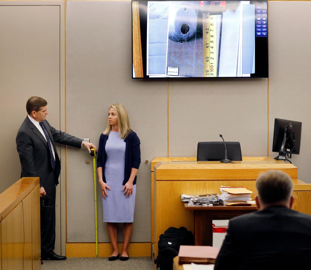 Defense attorney Toby Shook measures the height of a keyhole as fired Dallas police officer Amber Guyger stand against the courtroom wall as she testifies in her murder trial in Dallas on Sept. 27, 2019. (Tom Fox/The Dallas Morning News via AP, Pool)