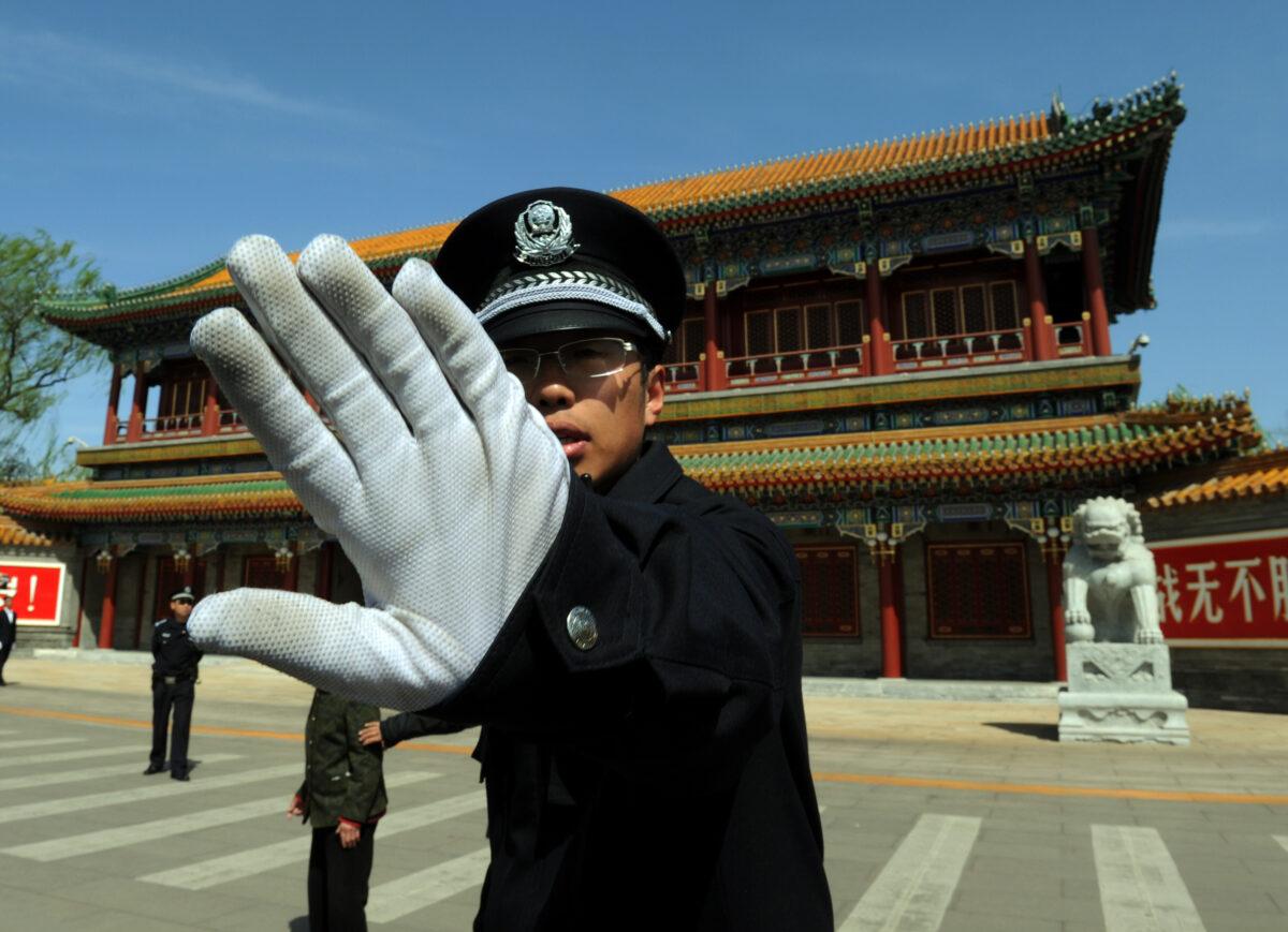 A Chinese policeman blocks photos being taken outside Zhongnanhai, which serves as the central headquarters for the Chinese Communist Party, in Beijing, on April 11, 2012. (Mark Ralston/AFP/Getty Images)
