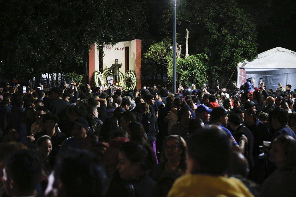 Fans gather to sing and remember Jose Jose while mourning his death at Jose Jose's statue in Mexico City, Saturday, Sept. 28, 2019. (AP Photo/Anthony Vazquez)