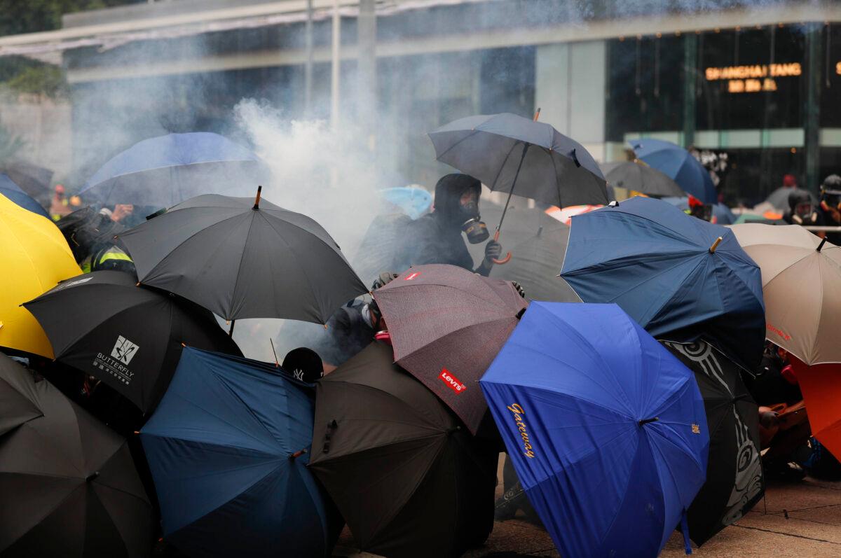 Protestors use umbrellas as shield as they face tear smoke from police in Hong Kong, on Sept. 29, 2019. (Vincent Thian/AP Photo)