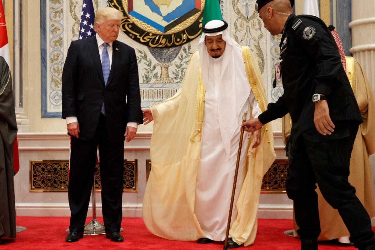 Saudi King Salman is helped by his bodyguard Maj. Gen. Abdulaziz al-Fagham (R), before taking photo with U.S. president Donald Trump, during the Gulf Cooperation Council meeting, in Riyadh, Saudi Arabia, on May 21, 2017. (Evan Vucci/AP Photo)