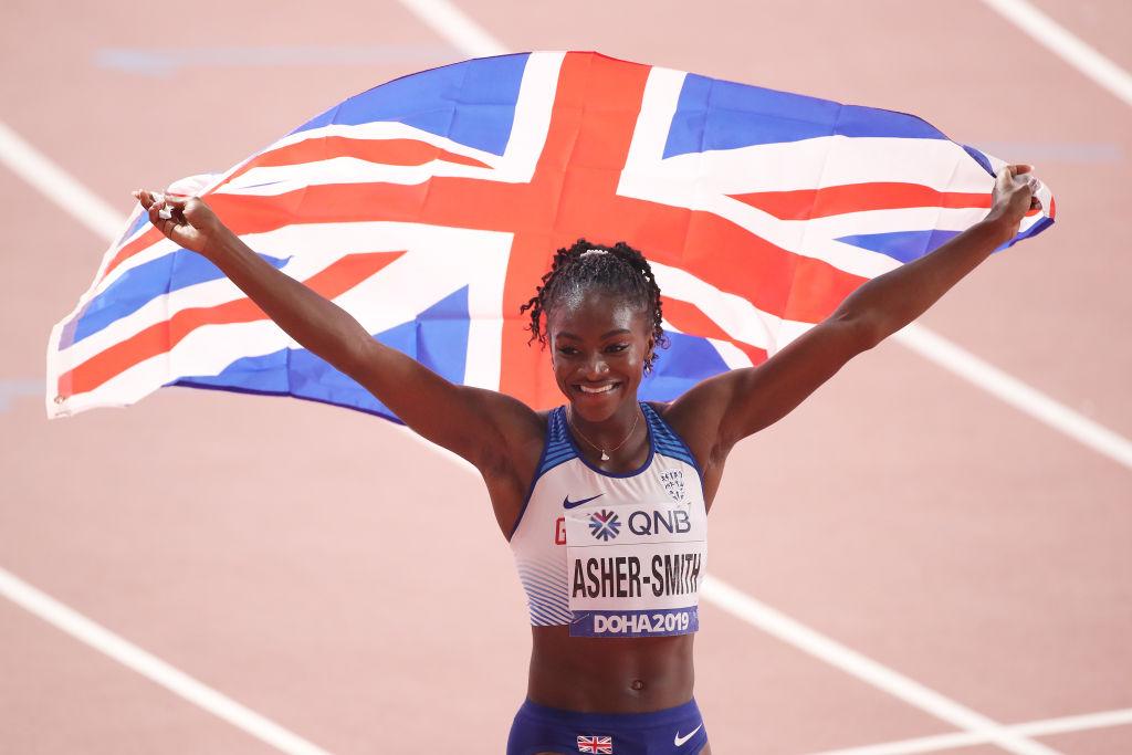 Asher-Smith celebrates her silver medal win by raising the Great British flag. (©Getty Images | <a href="https://www.gettyimages.com.au/detail/news-photo/dina-asher-smith-of-great-britain-celebrates-silver-in-the-news-photo/1177918051">Christian Petersen</a>)