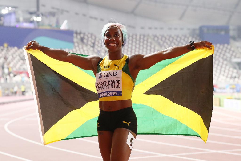 Fraser-Pryce celebrates winning gold by raising the Jamaican flag. (©Getty Images | <a href="https://www.gettyimages.com.au/detail/news-photo/shelly-ann-fraser-pryce-of-jamaica-celebrates-winning-the-news-photo/1177919312">Alexander Hassenstein</a>)
