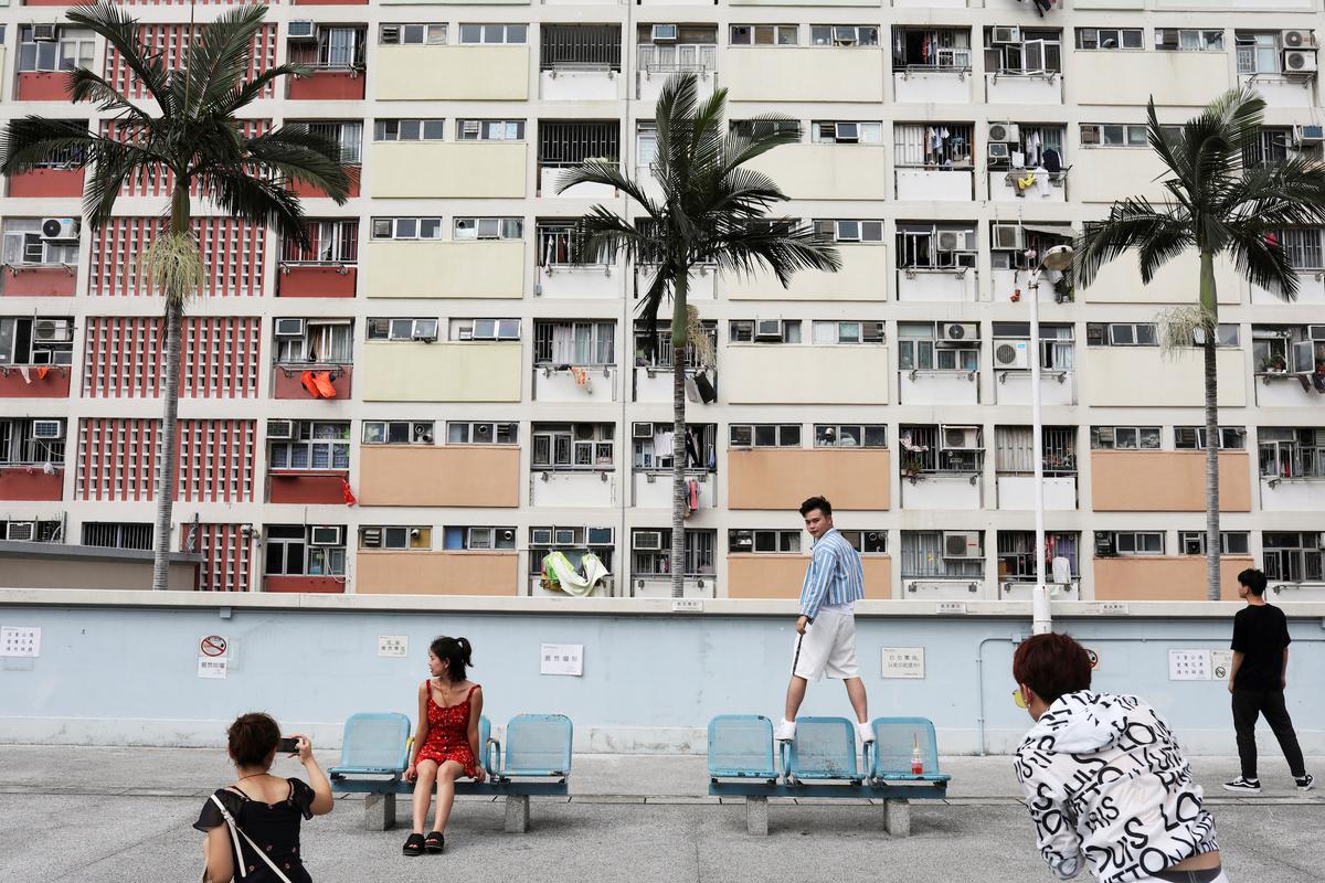 People take photo in front of Choi Hung estate, an apartment complex that became famous because of the rainbow color paints in Hong Kong, China on June 23, 2019. (Ann Wang/Reuters)