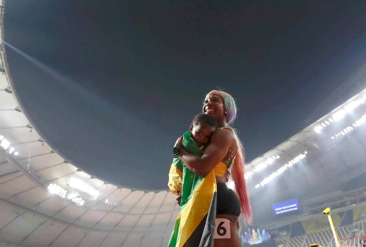 Shelly-Ann Fraser-Pryce of Jamaica with son Zyon after winning the gold medal in the women's 100 meter final at the World Athletics Championships in Doha, Qatar, on Sept. 29, 2019. (Petr David Josek/AP Photo)