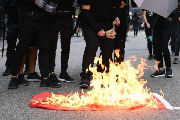 Protesters burn a Chinese national flag during a march through the streets of Hong Kong on Oct. 1, 2019. (Mohd Rasfan/AFP/Getty Images)
