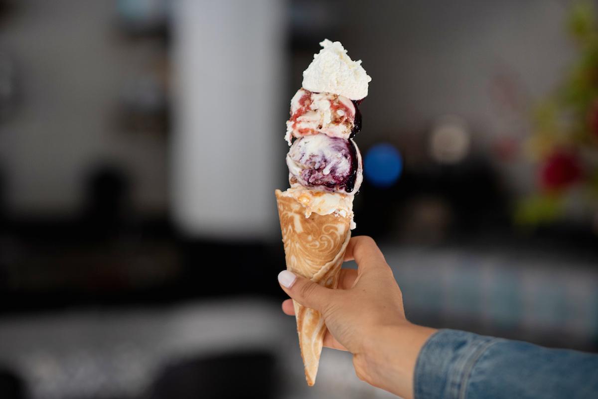 (Bottom to top) Apricot Olive Oil, Blackberry Crunch, and Red Flag (sweet cream with strawberry compote and graham crunch) on a housemade lingua di gatto (Italian butter cookie batter) cone. (Liz Clayman)