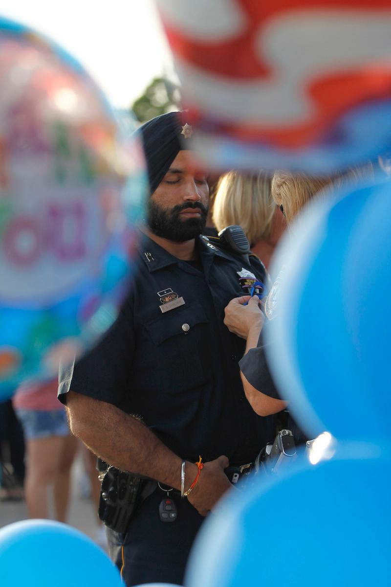 Harris County Sheriff's Deputy Sandeep Dhaliwal gets a blue ribbon pinned to him during a vigil held at the Chevron station on Aug. 29, 2015. (Karen Warren/Houston Chronicle)