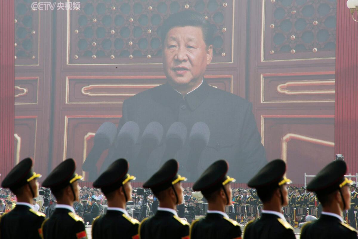 Soldiers of the People's Liberation Army are seen before a giant screen as Chinese leader Xi Jinping speaks at the military parade marking the 70th founding anniversary of the regime in Beijing on Oct. 1, 2019. (Jason Lee/Reuters)