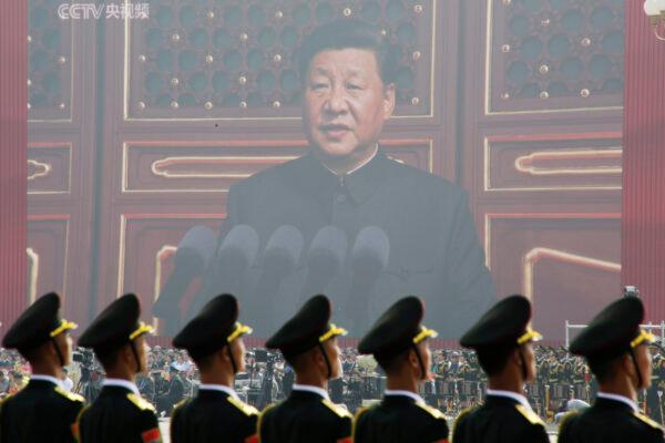 Soldiers of the People's Liberation Army are seen before a giant screen as Chinese leader Xi Jinping speaks at the military parade marking the 70th founding anniversary of the People's Republic of China on its National Day in Beijing on Oct. 1, 2019. (Jason Lee/Reuters)