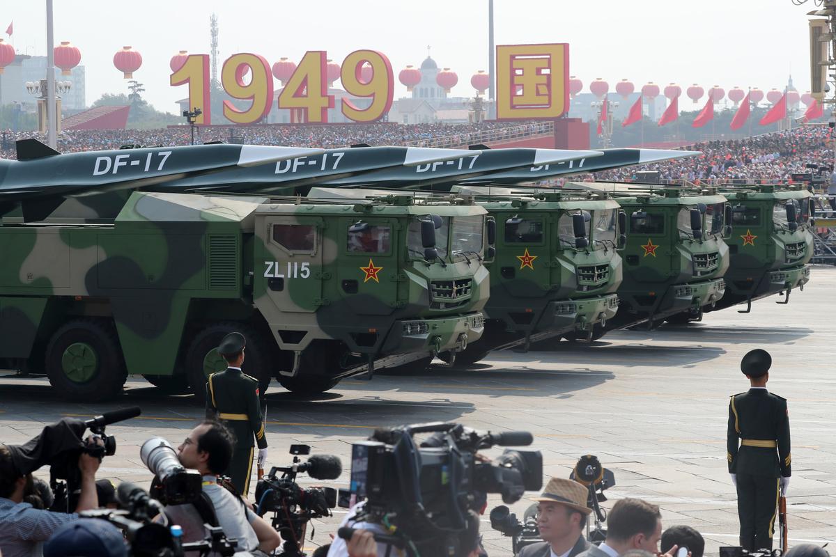 Military vehicles, carrying DF-17, roll down the street as members of a Chinese military honor guard march during the parade to commemorate the 70th anniversary of the founding of communist China in Beijing on Oct. 1, 2019. China's military has shown off a new hypersonic ballistic nuclear missile believed to be capable of breaching all existing anti-missile shields deployed by the United States and its allies. (AP Photo/Ng Han Guan)
