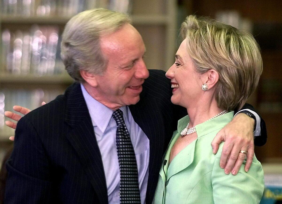 First Lady and U.S. Senate candidate Hillary Rodham Clinton, right, and U.S. Senator and vice-presidential candidate Joe Lieberman embrace as they appear together at a middle school in New York to campaign in 2000. (Matt Campbell/AFP/Getty Images)