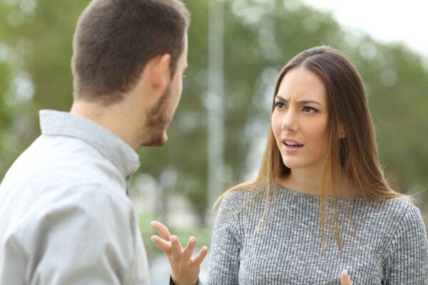Couple talking seriously outdoors in a park. (Shutterstock)