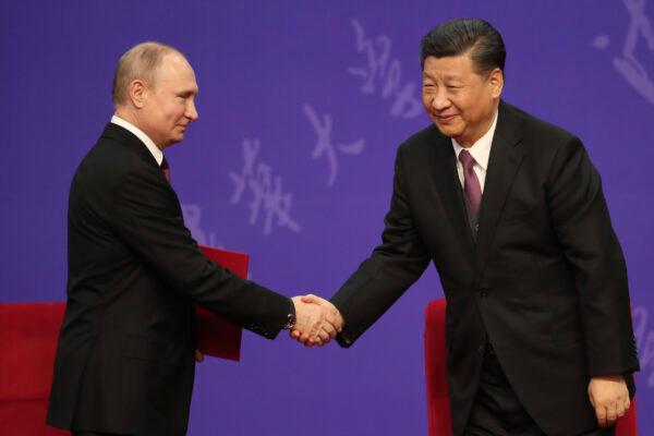 Russian President Vladimir Putin shakes hands with Chinese leader Xi Jinping during the Tsinghua University ceremony in Beijing, China, on April 26, 2019. (Kenzaburo Fukuhara/Pool/Getty Images)