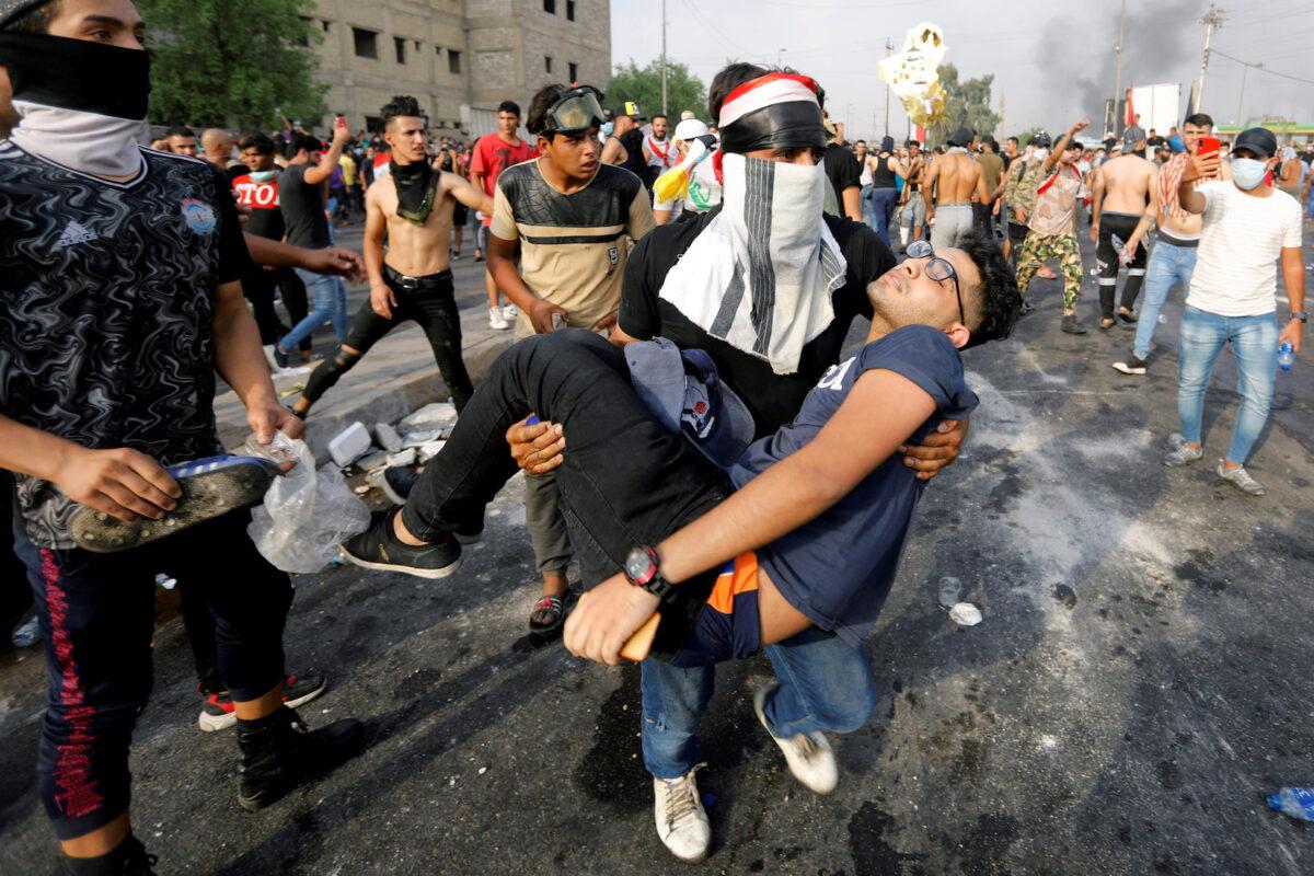 A man carries away a demonstrator, injured during a protest over unemployment, corruption, and poor public services, in Baghdad, Iraq on Oct. 2, 2019. (Khalid al-Mousily/Reuters)