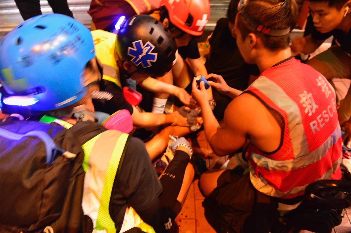 Medics surround the injured protester in Yuen Long, Hong Kong, on Oct. 4. (Yu Tianyou/The Epoch Times)