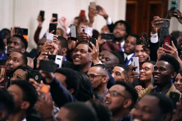 Guests cheer for President Donald Trump as he arrives at an event for the Young Black Leadership Summit in the East Room of the White House in Washington, on Oct. 4, 2019. (Chip Somodevilla/Getty Images)