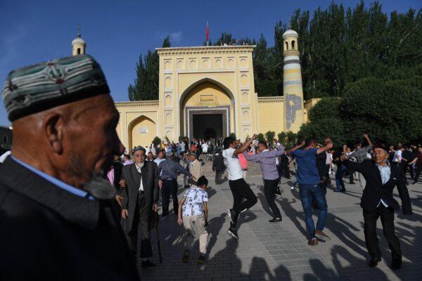 Uighur men dancing after Eid al-Fitr prayers, marking the end of Ramadan, outside the Id Kah mosque in Kashgar, in China's western Xinjiang region, on June 5, 2019. (Greg Baker/AFP/Getty Images)