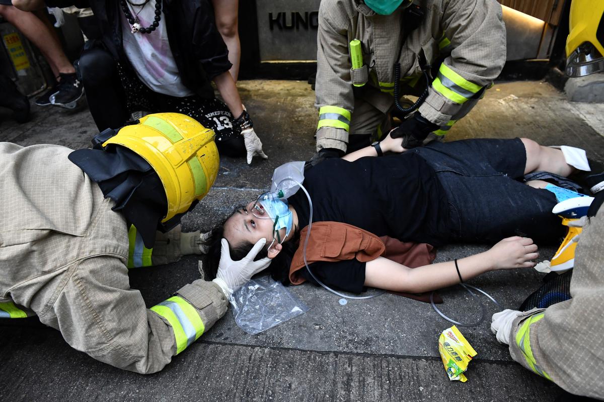A protester receives medical assistance after a taxi hit two protesters along Cheung Sha Wan Road during a demonstration in Hong Kong on Oct. 6, 2019. (Anthony Wallace/AFP via Getty Images)