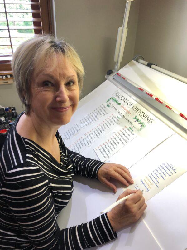 Patricia Lovett MBE, a title that stands for Member of the Order of the British Empire, in her workroom on Oct. 6, 2019, having finished writing an extract from Shakespeare’s "Henry V" with a quill on vellum. A rough draft for a list of rectors for Chevening Church is in the background. (Courtesy of Patricia Lovett)