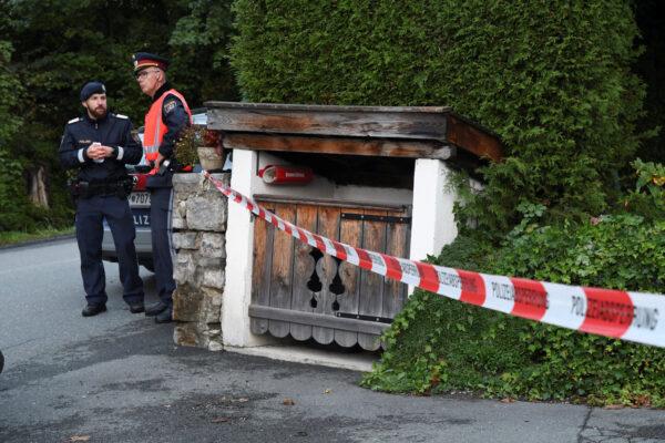 Police officers stand in front of a house where, according to police, five people were found dead in Kitzbühel, Austria, on Oct. 6, 2019. (Zoom.Tirol via Reuters)