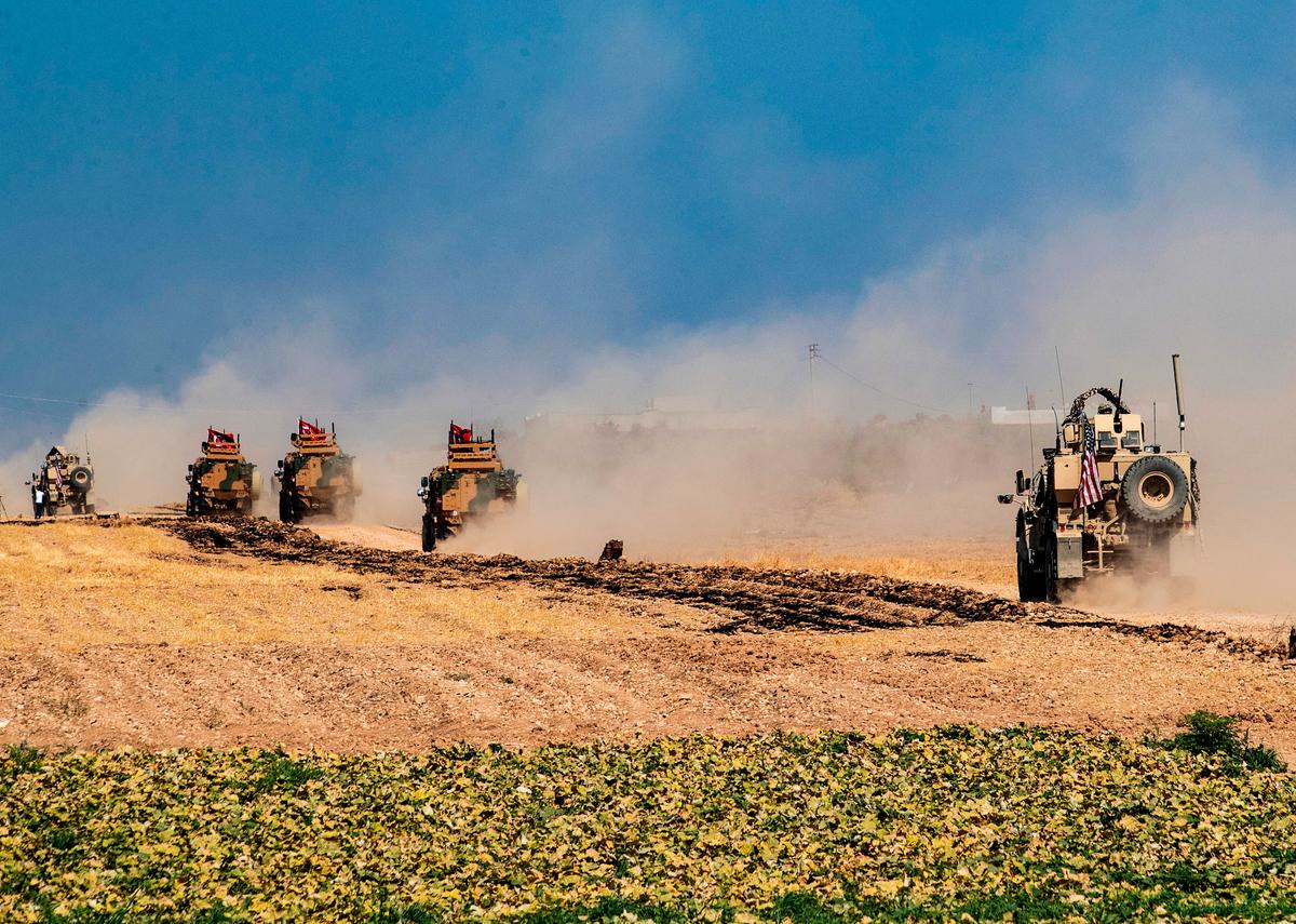 Turkish and U.S. military vehicles, take part in joint patrol in the Syrian village of al-Hashisha on the outskirts of Tal Abyad town along the border with Turkey, on Oct. 4, 2019. (Delil Souleiman/AFP/Getty Images)