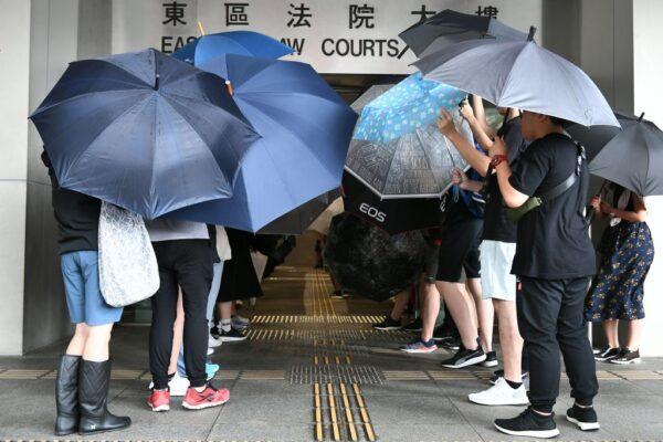 Protesters cover themselves with umbrellas as they gather outside the Eastern District Courts in Hong Kong on Oct. 7, 2019, where the first protesters arrested for wearing face masks appeared in court. (Mohd Rasfan/AFP via Getty Images)