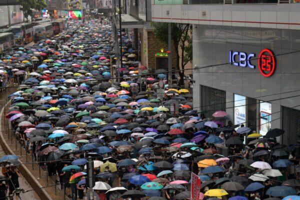 People take part in a rainy protest march from the Causeway Bay shopping district of Hong Kong on Oct. 6, 2019. (NICOLAS ASFOURI/AFP via Getty Images)