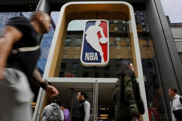 The NBA logo is displayed as people pass by the NBA Store in New York on Oct. 7, 2019. (Brendan McDermid/Reuters)