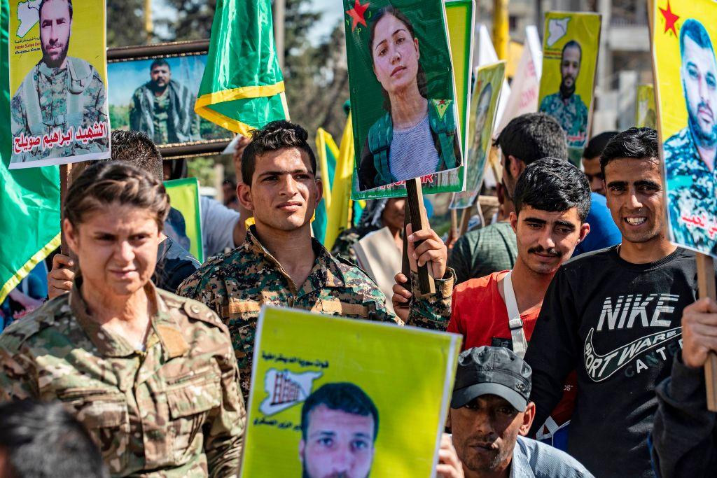 Fighters and veterans from the Kurdish women's protection units (YPJ) and the people's protection units (YPG) march in front of the UN headquarters in the northern Kurdish Syrian city of Qamishli during a protest against Turkish threats in the Kurdish region, on Oct. 8, 2019. (Delil Souleiman/AFP via Getty Images)