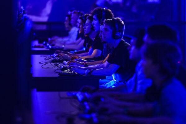 Visitors try out games at the Blizzard Entertainment stand at the Gamescom 2015 gaming trade fair in Cologne, Germany on August 5, 2015. (Sascha Schuermann/Getty Images)