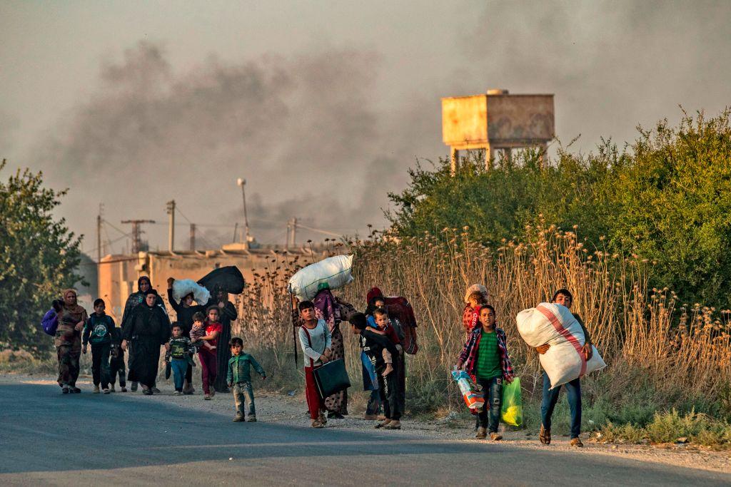 Civilians flee with their belongings amid Turkish bombardment on Syria's northeastern town of Ras al-Ain in the Hasakeh province along the Turkish border on Oct. 9, 2019. (Delil Souleiman/AFP via Getty Images)