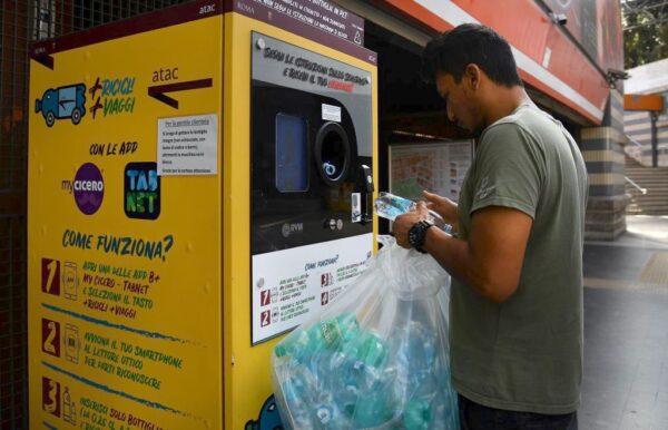 A commuter trades plastic bottles for transit credit at a reverse vending machine on October 8, 2019 at the Cipro underground metro station on the A-line in Rome. - Commuters in Rome can save cash and act for the environment by swapping plastic for transit credits. At three stations in Rome, Cipro on the A-line, Piramide on the B-line and San Giovanni on the C-line, commuters can recycle plastic bottles in reverse vending machines in exchange for credits that can be used towards bus and metro tickets. (Photo by Tiziana FABI / AFP) (Photo by TIZIANA FABI/AFP via Getty Images)