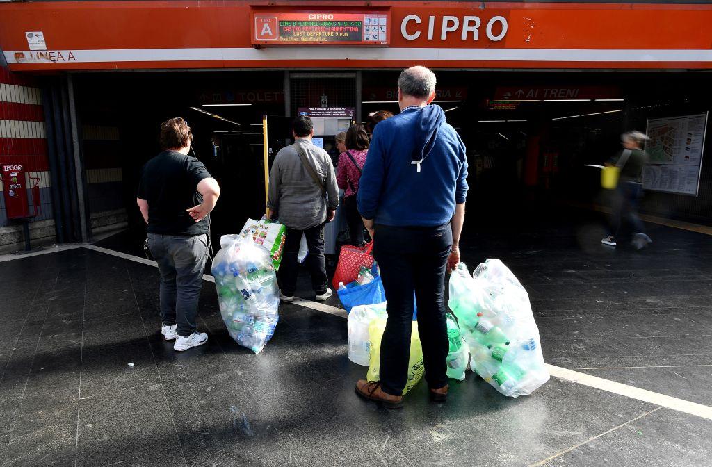 Commuters in Rome line up to trade plastic bottles for transit credit at a reverse vending machine on Oct. 8, 2019. (©Getty Images | <a href="https://www.gettyimages.com.au/detail/news-photo/commuters-line-up-to-trade-plastic-bottles-for-transit-news-photo/1174492571">TIZIANA FABI/AFP</a>)