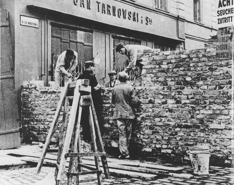 Construction of the Warsaw ghetto wall during the German occupation of Poland (<a href="https://commons.wikimedia.org/wiki/File:The_Wall_of_ghetto_in_Warsaw_-_Building_on_Nazi-German_order_August_1940.jpg">Wikimedia Commons</a>)